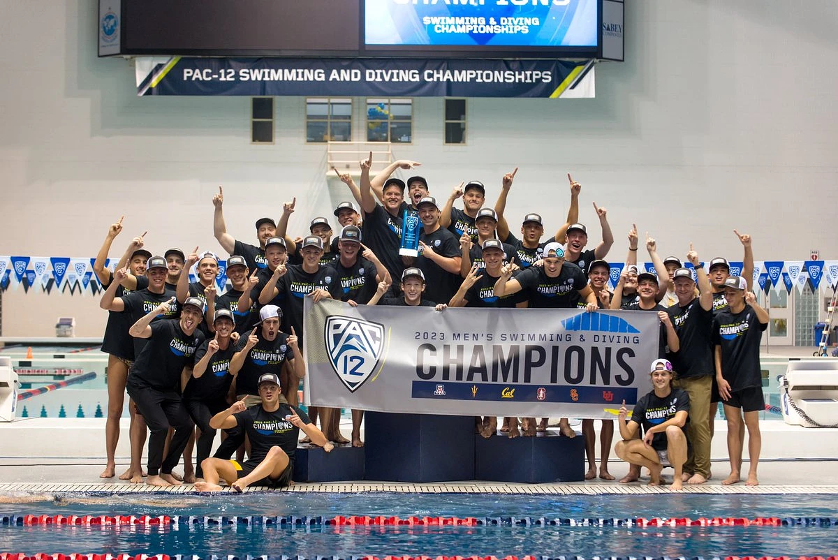 Group photo of swim team holding a sign