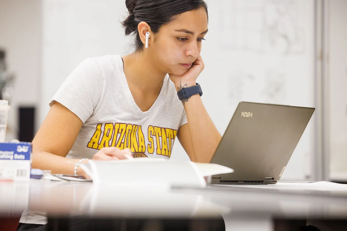 Woman working on her computer with Airpod in her ear