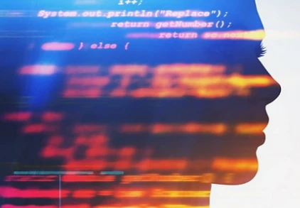 A person's face illuminated by the projection of lines of computer code.