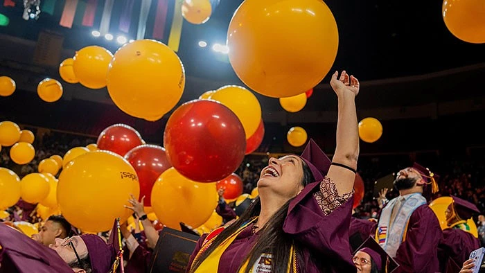 graduate surrounded by balloons