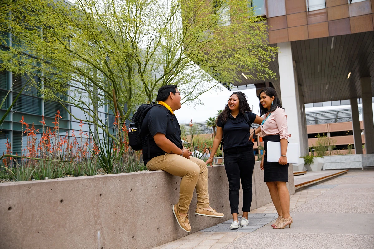 students standing outside academic building while talking