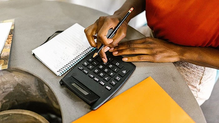 person typing into calculator 
