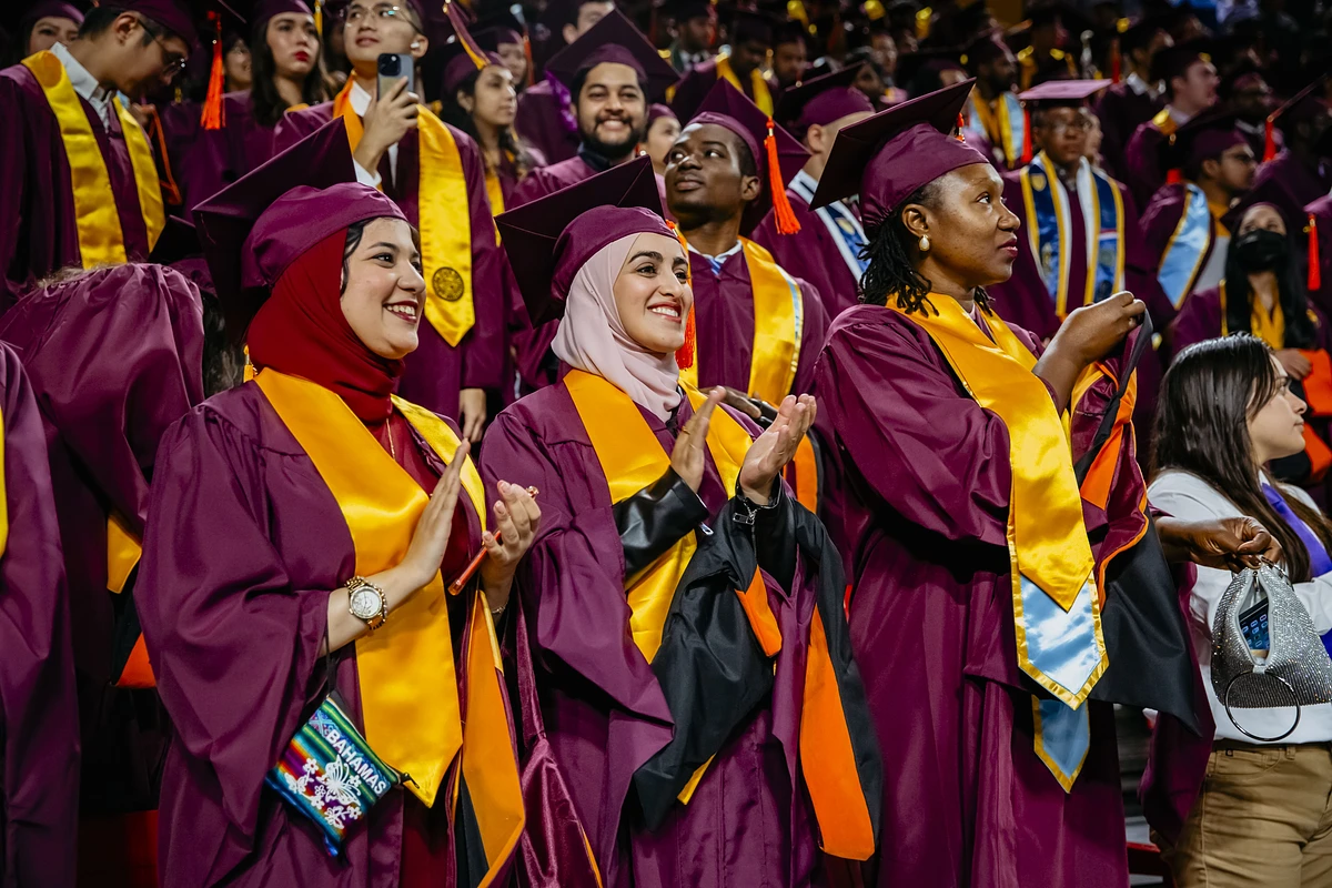 Several ASU students clap and cheer during the commencement ceremony