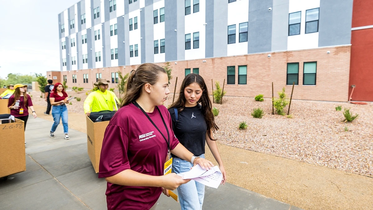 A group of people are moving into a university dormitory building.